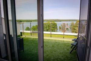 balkon z widokiem na wodę w obiekcie Apartamenty Białe Tomasza 4 w mieście Augustów