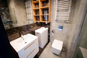 łazienka z białą umywalką i toaletą w obiekcie Apartamenty Białe Tomasza 4 w mieście Augustów