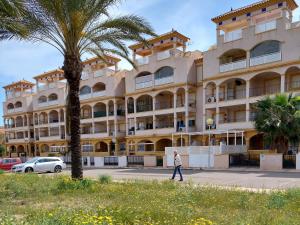 a person walking in front of a large building at Apartamenty Boutique Mar De Cristal in Mar de Cristal