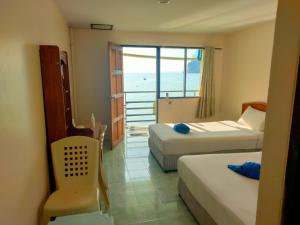 a hotel room with two beds and a view of the ocean at Dalum Beachhouse in Phi Phi Islands