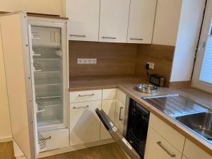 a small kitchen with white cabinets and a sink at Apartment Van Eß Hof - Altstadt Warburg in Warburg