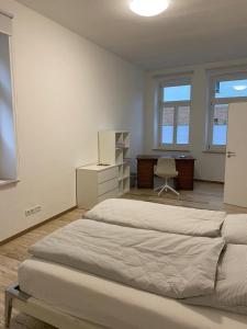 a bedroom with two beds and a desk and a chair at Apartment Van Eß Hof - Altstadt Warburg in Warburg