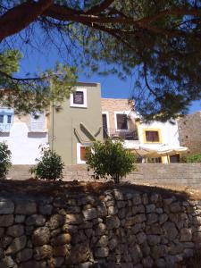 a house with a stone wall in front of it at Casa Con Vista Apartments in Halki
