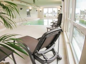 two chairs sitting on a porch next to a swimming pool at HP Touristik - Residenz Hohe Lith Neu 3 1 2 in Cuxhaven