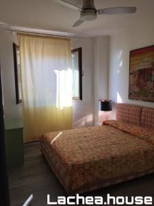 ein Hotelzimmer mit einem Bett und einem Fenster in der Unterkunft Lachea House appartamento sul mare dei Ciclopi in Aci Castello