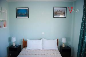 OLIVES Estate APARTMENTS Grande في بريفيزا: غرفة نوم بسرير وصورتين على الحائط