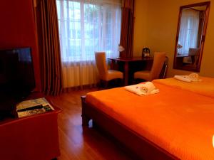 a hotel room with two beds and a television at Guest House Poilsis Jums in Klaipėda