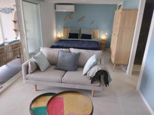 a living room with a couch and a bed at Le Spot 577 in La Ciotat