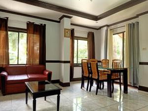 a living room with a couch and a table and chairs at The Gabriella Bed and Breakfast in Tagbilaran City