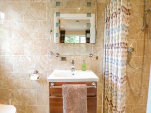 une salle de bain avec un lavabo et un miroir dans l'établissement Birch Cottage, à Norwich 22 autres photos