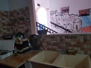 encimera de cocina con fregadero y ventana en Auberge Alferdaous, en Tataouine