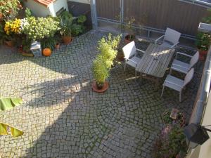 a patio with a table and chairs and potted plants at Ferienwohnung Prinke in Niedertrebra