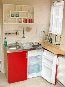 a kitchen with a sink and a red cabinet at Ferienwohnung Prinke in Niedertrebra