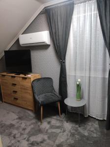 salon z telewizorem, krzesłem i stołem w obiekcie Pensjonat Klimat Bircza w mieście Bircza