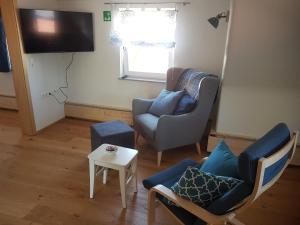 a living room with two chairs and a tv at Lamm - Wohnung 3 in Spiegelberg