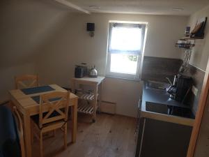 eine Küche mit einem Tisch, einem Waschbecken und einem Fenster in der Unterkunft Wohnung 3 - a69942 in Spiegelberg