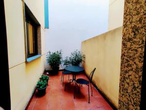 un patio con mesa, sillas y plantas en Alojamiento Real Monforte de Lemos, en Monforte de Lemos