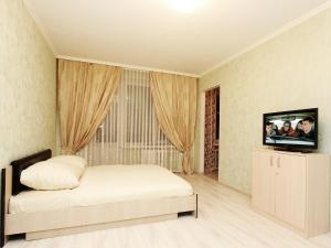 a bedroom with a bed and a flat screen tv at ApartLux Arbatskaya in Moscow