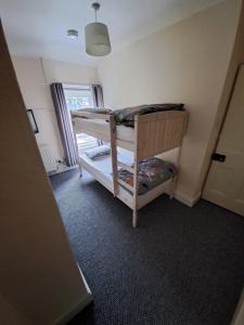 een kleine kamer met 2 stapelbedden en een raam bij Entire town house with free parking in Oswestry