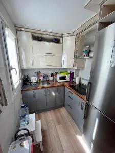 a kitchen with white cabinets and a stainless steel refrigerator at Molino Blanco Apartment in Torrevieja