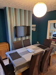 a dining room with a table and chairs and a television at Entire town house with free parking in Oswestry