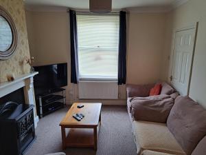 a living room with a couch and a coffee table at Entire town house with free parking in Oswestry