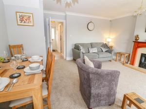 uma sala de estar com uma mesa de jantar e um sofá em Woolpack Cottage em Stow on the Wold