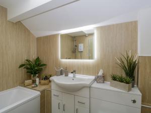 a bathroom with a sink and a mirror at Columbine Cottage in Ambleside