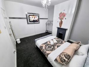 a bedroom with a bed with a fireplace and a tv at *11BR* Setup for your most amazing relaxed stay + Free Parking + Free Fast WiFi * in Beeston