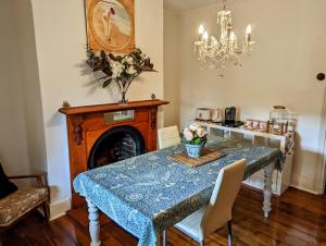 a dining room with a table and a chandelier at Hamptons Historic Guest House in Littlehampton