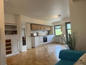 a large kitchen with white cabinets and a blue couch at Apartment Wendelsteinblick - Wohnen auf Zeit - Homeoffice - Balkon mit Bergblick- buchbar ab 28 Nächte in Schliersee