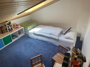 a small bedroom with a bed and two chairs at Apartment Wendelsteinblick - Wohnen auf Zeit - Homeoffice - Balkon mit Bergblick- buchbar ab 28 Nächte in Schliersee