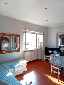 salon z 2 łóżkami i stołem w obiekcie Appartamento luminosissimo con vista panoramica w mieście Marina di Cerveteri