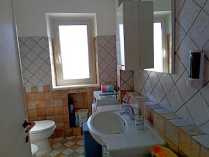 łazienka z umywalką i toaletą w obiekcie Appartamento luminosissimo con vista panoramica w mieście Marina di Cerveteri