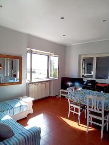 salon ze stołem i kanapą w obiekcie Appartamento luminosissimo con vista panoramica w mieście Marina di Cerveteri