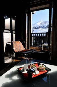 een dienblad met eten op een tafel met uitzicht op de oceaan bij Avenue Lodge Hotel & Spa in Val dʼIsère