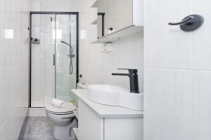 マラガにあるHomey Apt- Ático con vistas a la catedralのトイレと洗面台を備えた白いバスルーム +15枚の写真