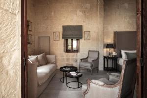 a living room with a couch and a table and chairs at Cesca's Boutique Hotel in Xlendi