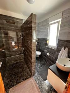 y baño con ducha, lavabo y aseo. en Villa Sanja I, en Trogir