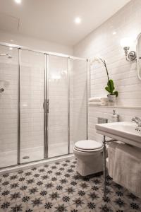 a bathroom with a shower and a toilet and a sink at Cesca's Boutique Hotel in Xlendi