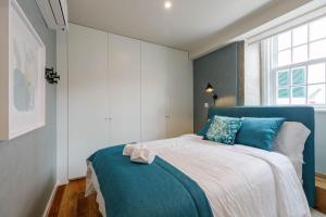 - une chambre avec un lit bleu et blanc et une fenêtre dans l'établissement Green Apartment Foz, à Porto