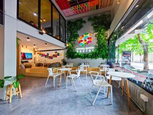 a restaurant with white tables and white chairs at Everyday Bangkok Hostel in Bangkok