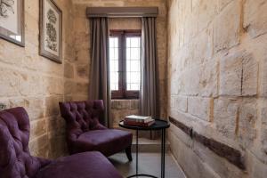 a room with two chairs and a table at Cesca's Boutique Hotel in Xlendi