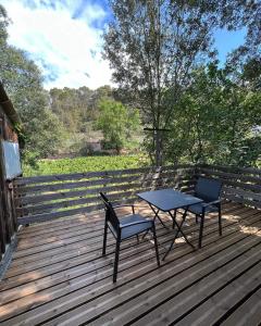 a picnic table and two chairs on a wooden deck at Comorebi Provence in Entrecasteaux