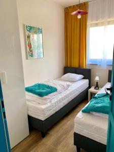 1 dormitorio con 2 camas y ventana en Apartamenty Czerwone Korale, en Chłopy