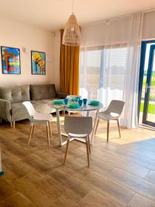 ein Wohnzimmer mit einem Tisch, Stühlen und einem Sofa in der Unterkunft Apartamenty Czerwone Korale in Chłopy