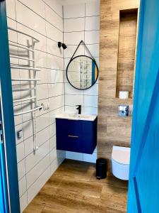 y baño con lavabo azul y espejo. en Apartamenty Czerwone Korale, en Chłopy