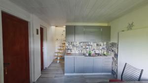 eine Küche mit weißen Schränken und einem Waschbecken in der Unterkunft FELICITA in Fužine