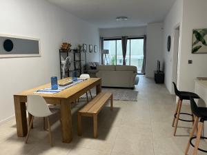 uma sala de estar com uma mesa de madeira e cadeiras em Coastal View em Grand Baie