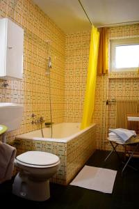 a bathroom with a bath tub and a toilet at Hiša ob jezeru - House by the Lake in Kranjska Gora